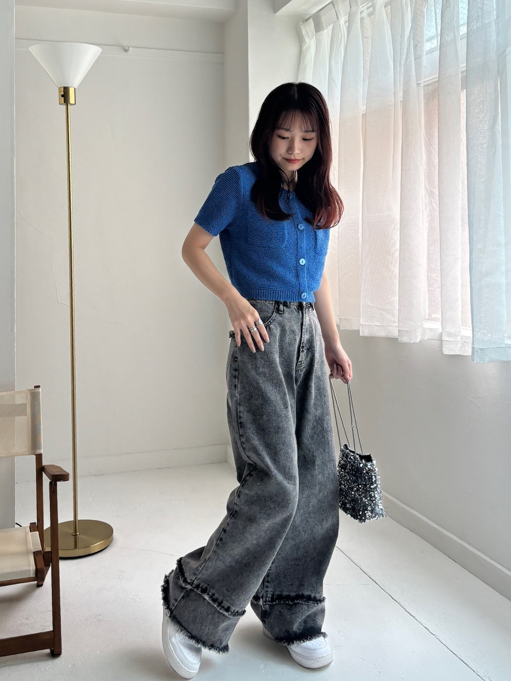 グレー系のデニムパンツ、ブルー系のカーディガン/ボレロ、ホワイト系のスニーカーを着用したレディースの夏コーディネートの4枚目の写真