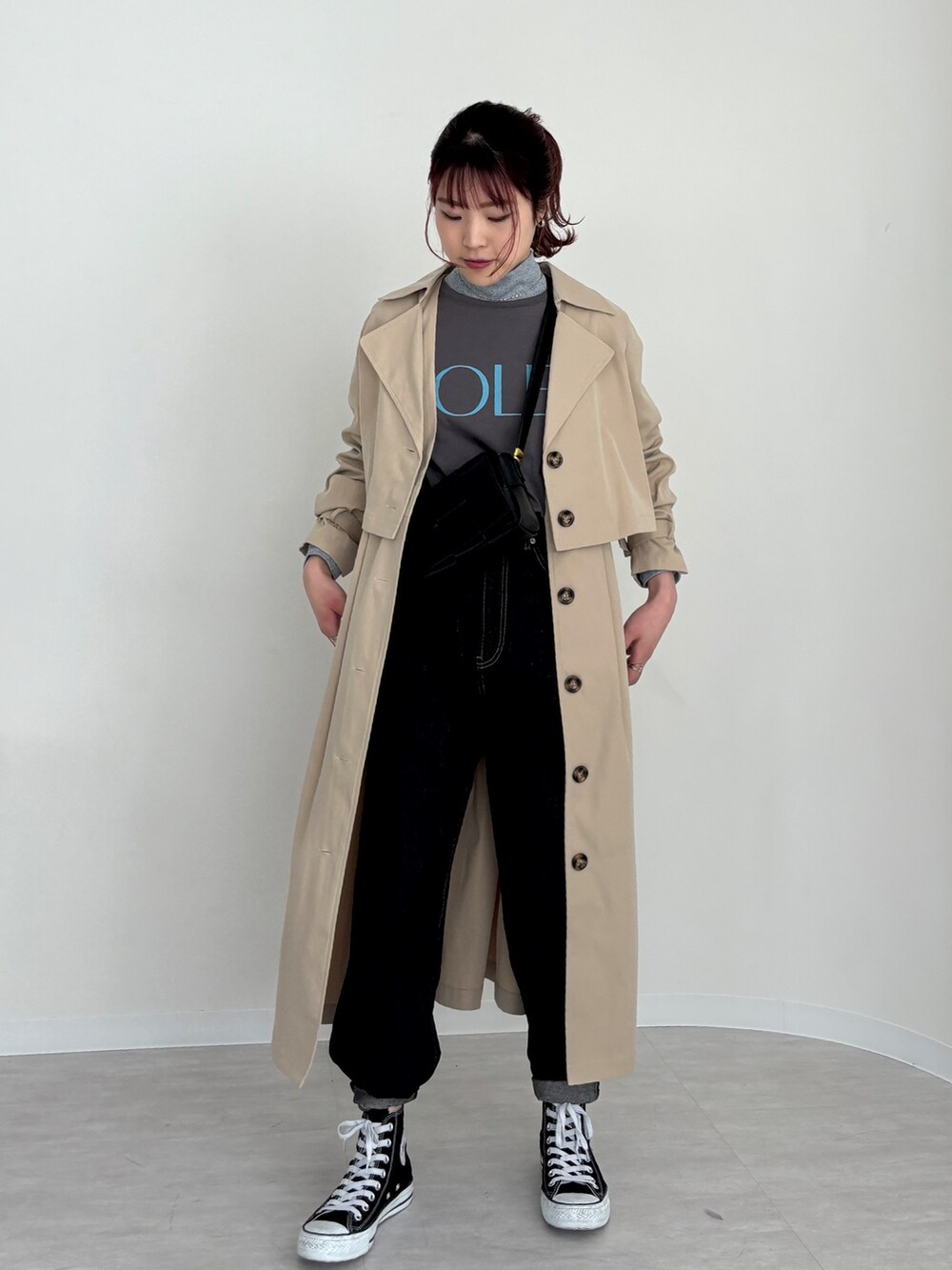 ブラック系のデニムパンツ、グレー系のTシャツ/カットソー、ベージュ系のトレンチコートを着用したレディースの春コーディネートの2枚目の写真