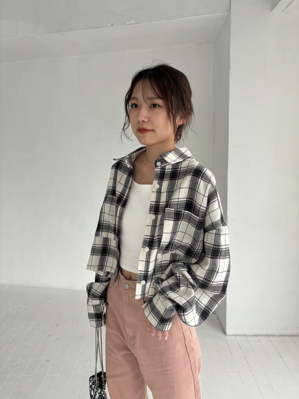 ホワイト系のキャミソール、ピンク系のデニムパンツ、ホワイト系のスニーカーを着用したレディースの秋コーディネートの3枚目の写真