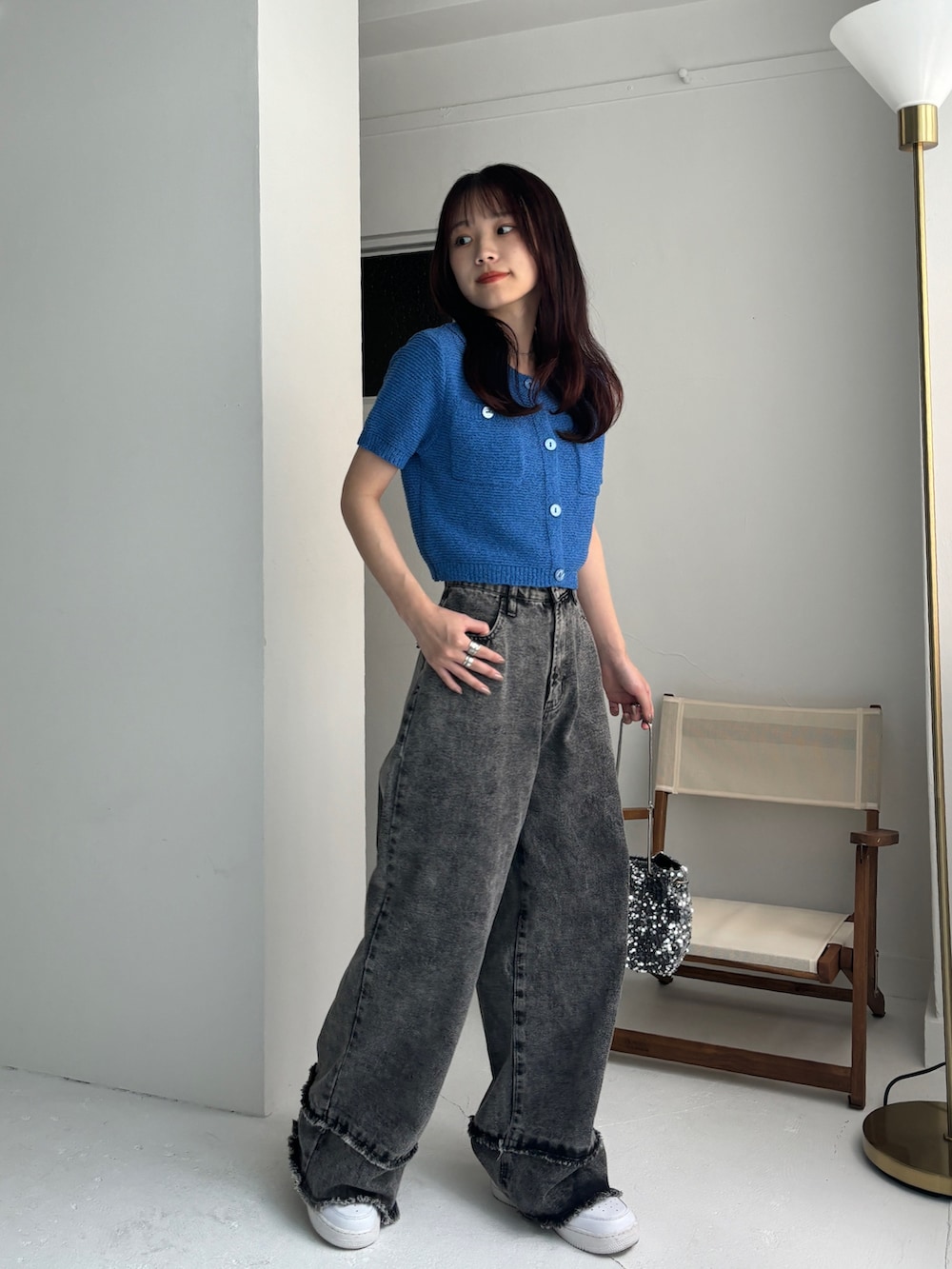 グレー系のデニムパンツ、ブルー系のカーディガン/ボレロ、ホワイト系のスニーカーを着用したレディースの夏コーディネートの2枚目の写真