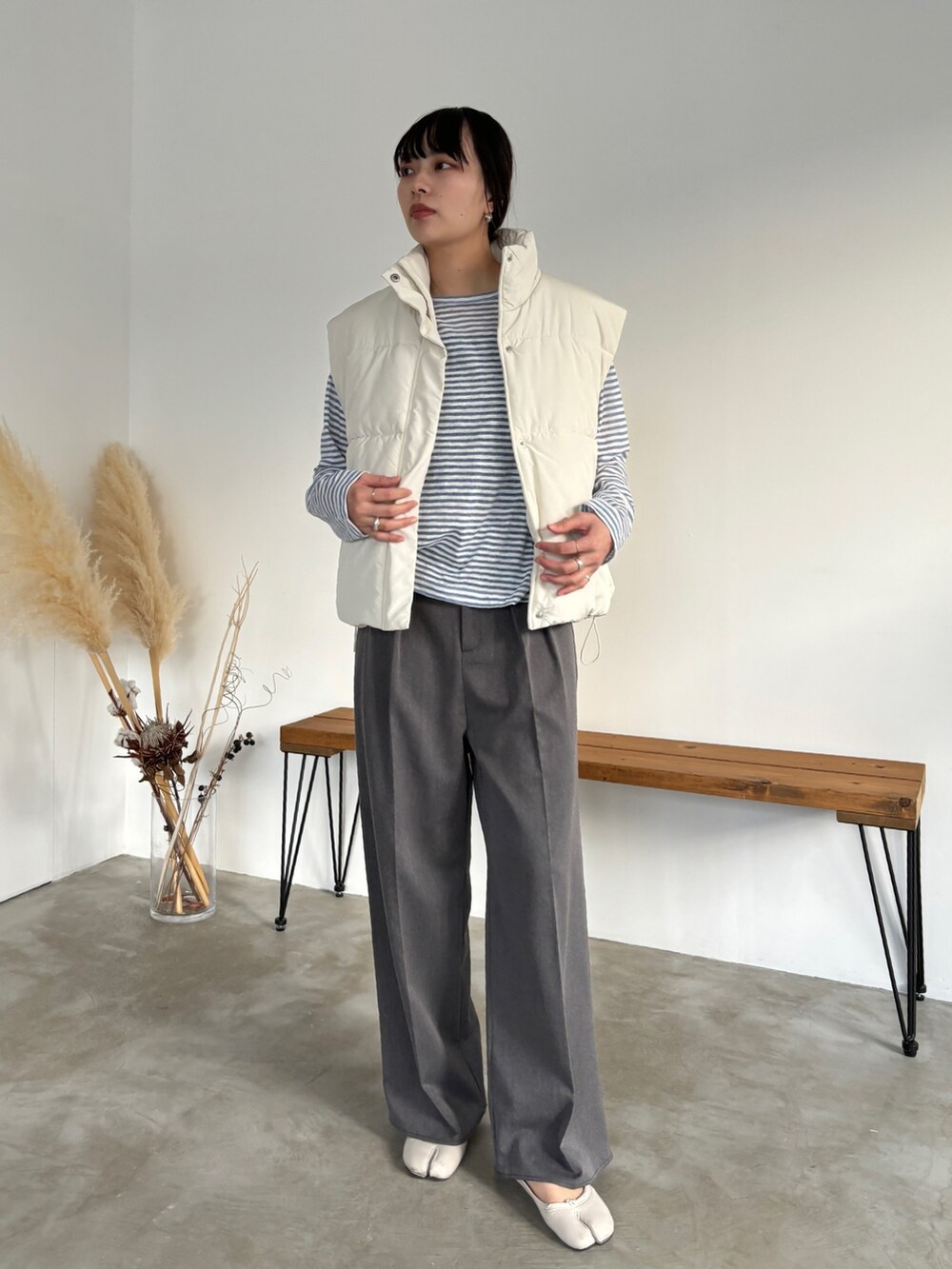 ホワイト系のベスト、グレー系のスラックス、その他のその他を着用したレディースの冬コーディネートの2枚目の写真