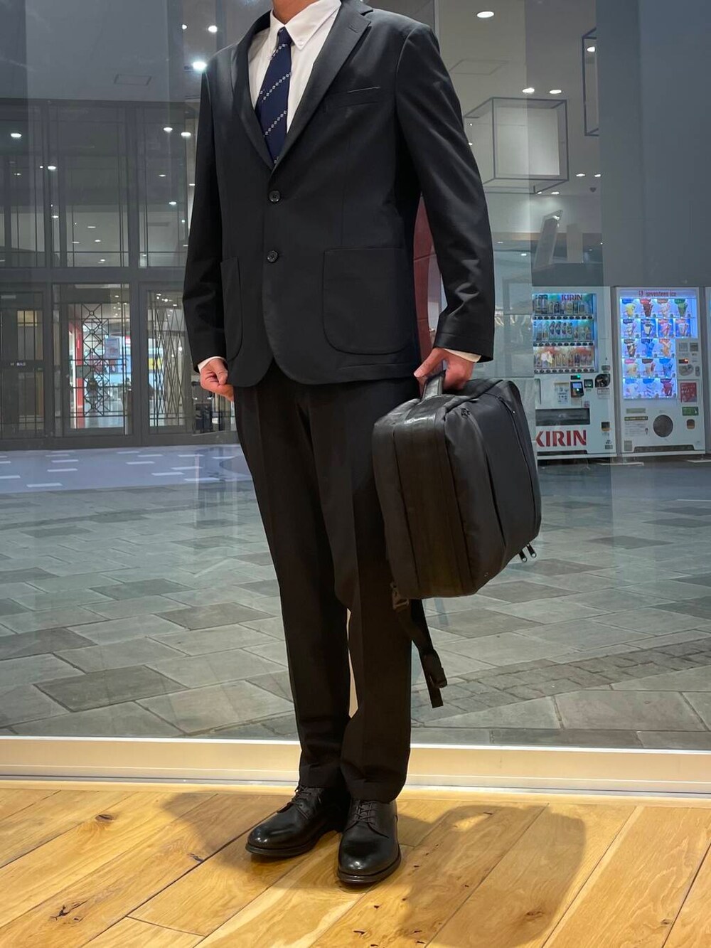ブラック系のドレスシューズ、ホワイト系のシャツ/ブラウス、ブルー系のスーツジャケットを着用したメンズの冬コーディネートの2枚目の写真