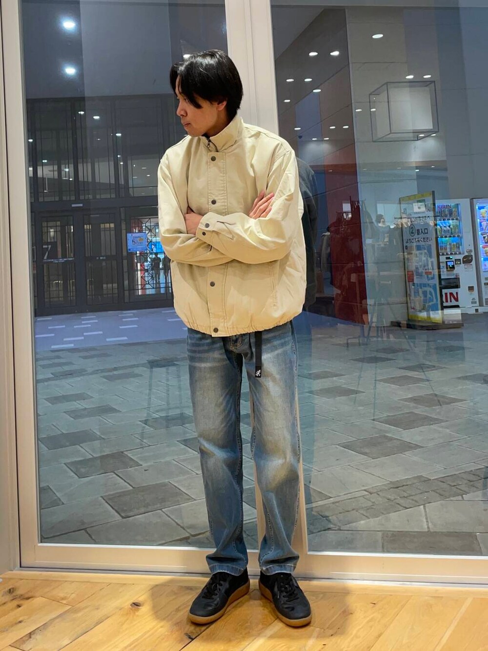 ブルー系のデニムパンツ、ブラック系のスニーカー、ベージュ系のTシャツ/カットソーを着用したメンズの秋コーディネートの4枚目の写真