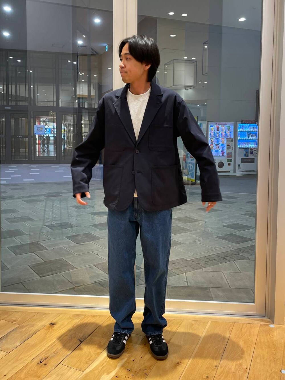 ブルー系のデニムパンツ、グレー系のスウェット、ブラック系のスニーカーを着用したメンズの秋コーディネートの4枚目の写真