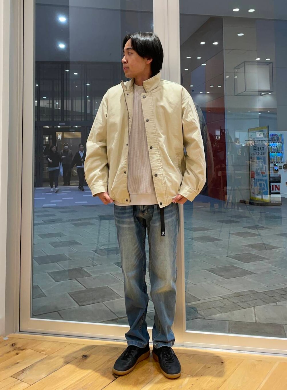 ブルー系のデニムパンツ、ブラック系のスニーカー、ベージュ系のTシャツ/カットソーを着用したメンズの秋コーディネートの3枚目の写真