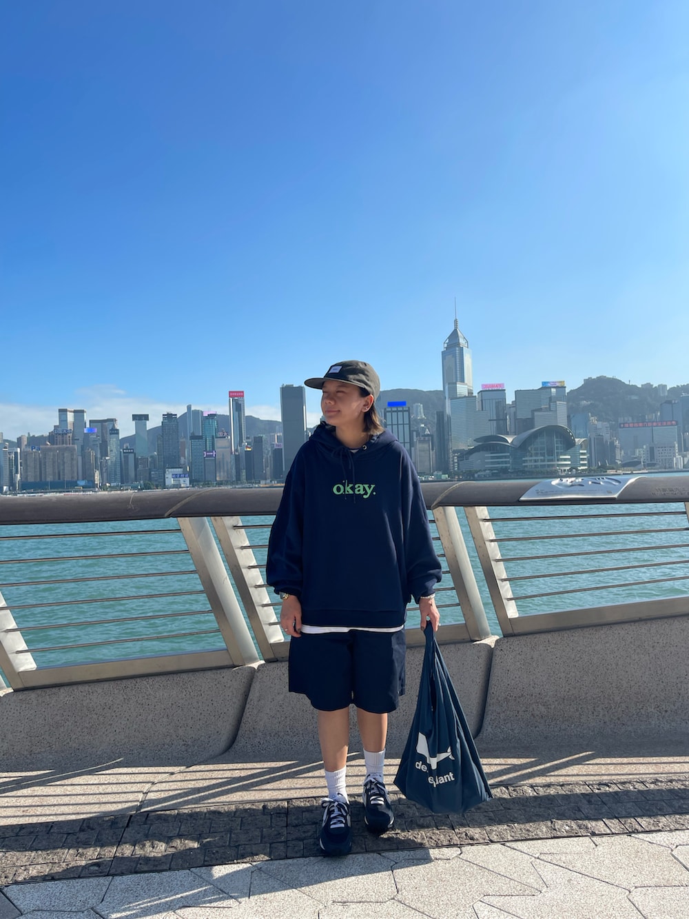 ブルー系のスニーカー、グレー系のキャップを着用したレディースの秋コーディネートの2枚目の写真