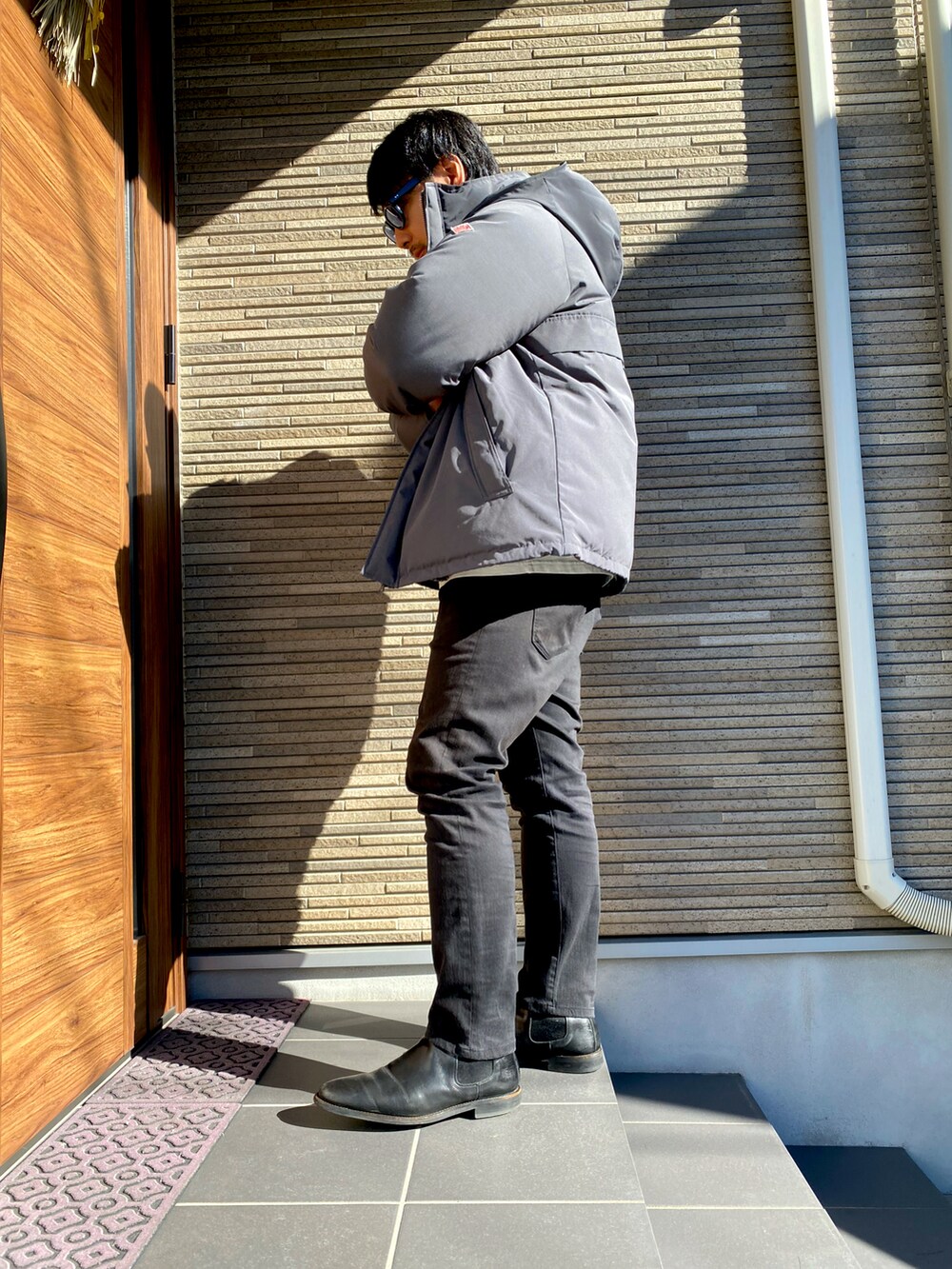 ブラック系のブーツ、ブルー系のデニムパンツ、ホワイト系のTシャツ/カットソーを着用したメンズの冬コーディネートの4枚目の写真