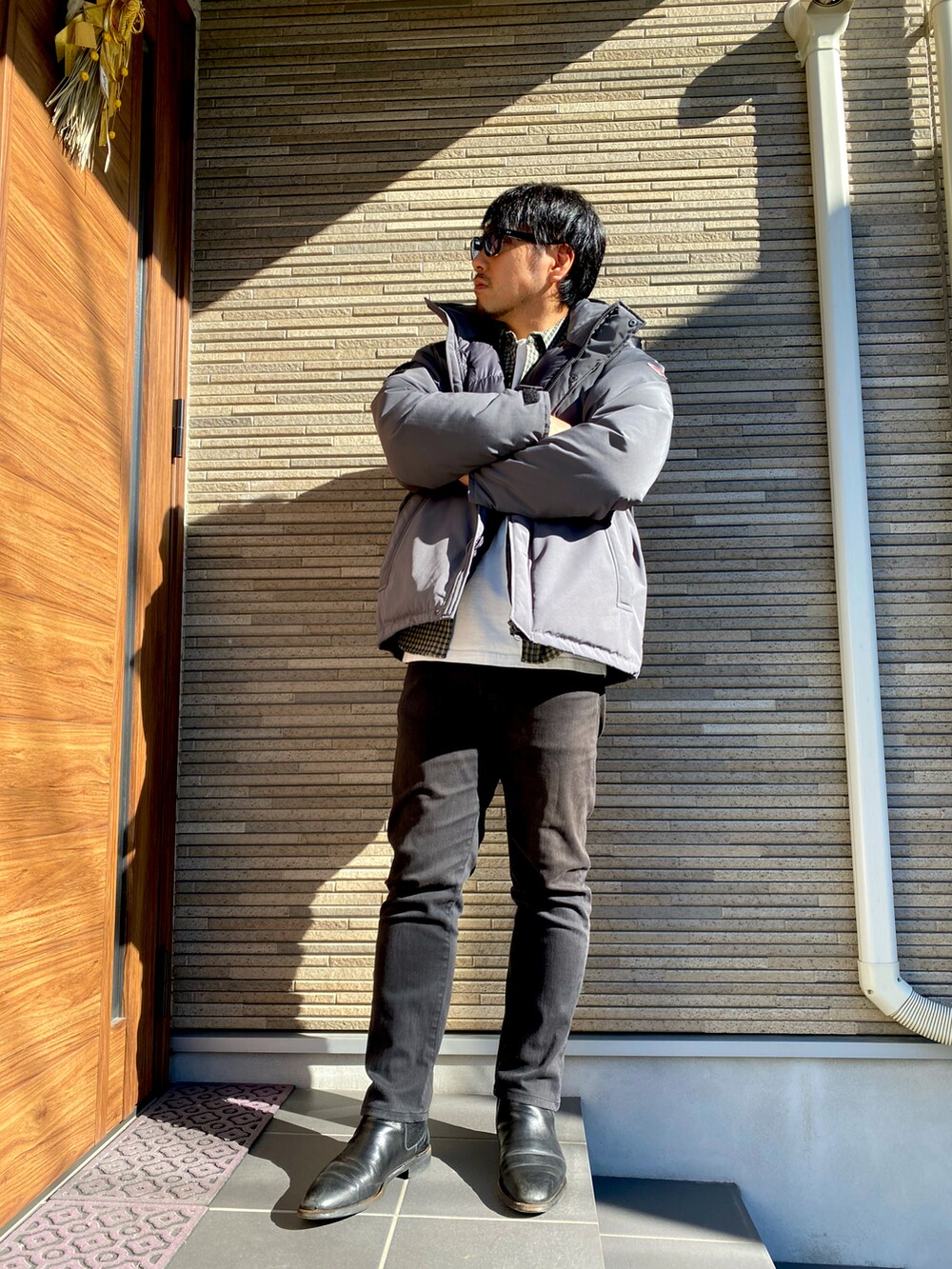 ブラック系のブーツ、ブルー系のデニムパンツ、ホワイト系のTシャツ/カットソーを着用したメンズの冬コーディネートの3枚目の写真