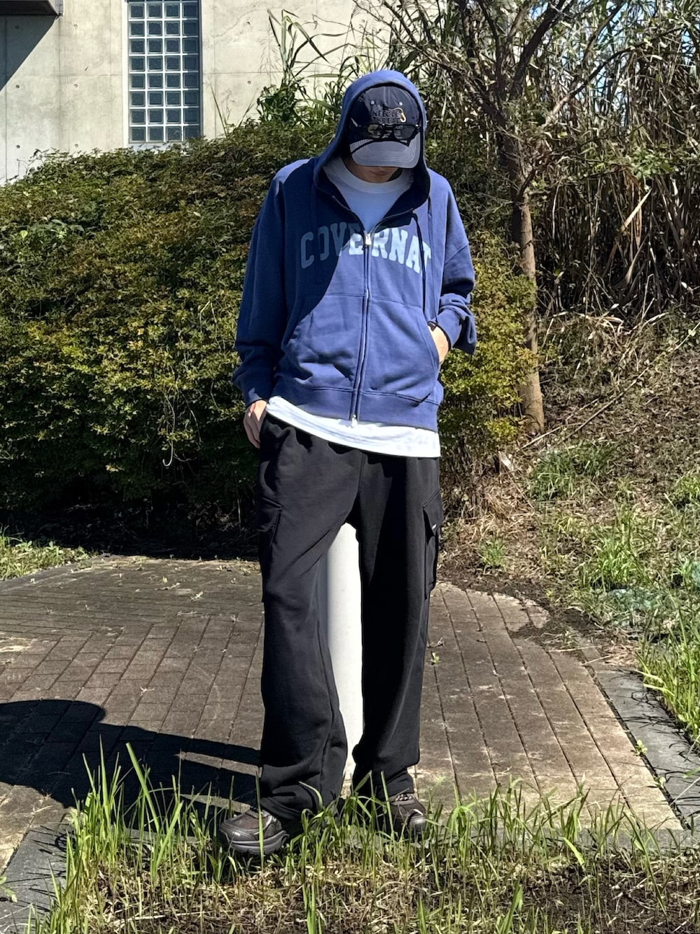 ブルー系のパーカー、ブラック系のスウェットパンツ、ブラウン系のシューズを着用したメンズの秋コーディネートの2枚目の写真