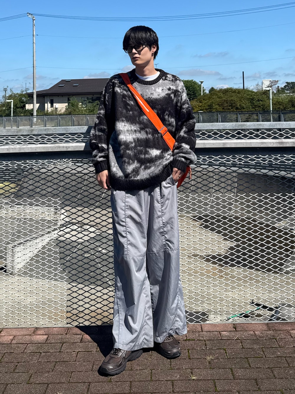 グレー系のパンツ、ブラック系のニット/セーターを着用したメンズの秋コーディネートの2枚目の写真
