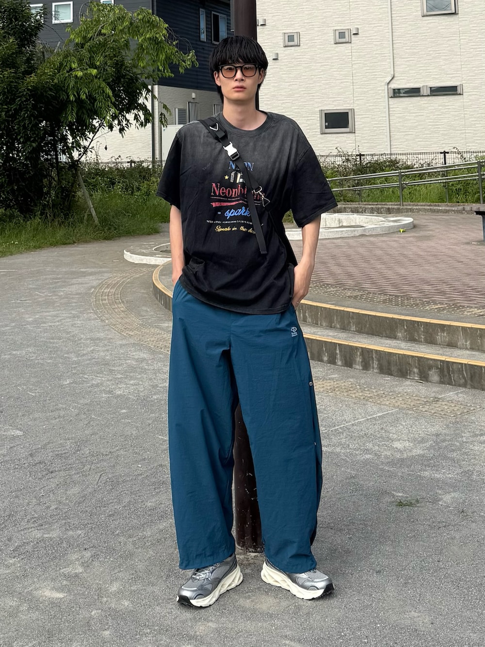 グレー系のスニーカー、ブルー系のカーゴパンツを着用したメンズの夏コーディネートの2枚目の写真