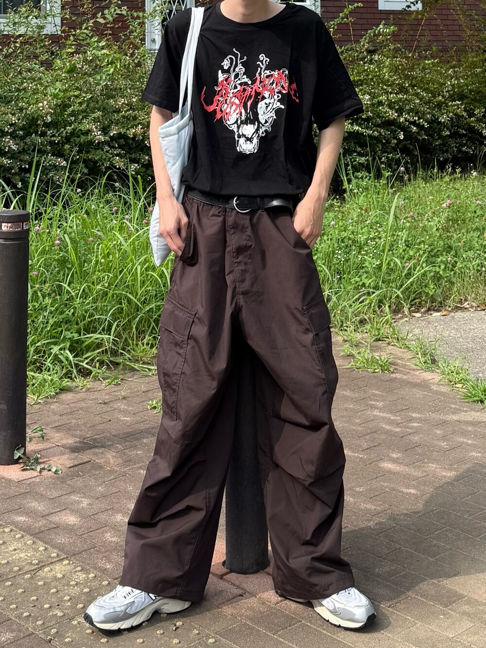 ブラック系のTシャツ/カットソー、ブラウン系のカーゴパンツを着用したメンズの夏コーディネートの3枚目の写真