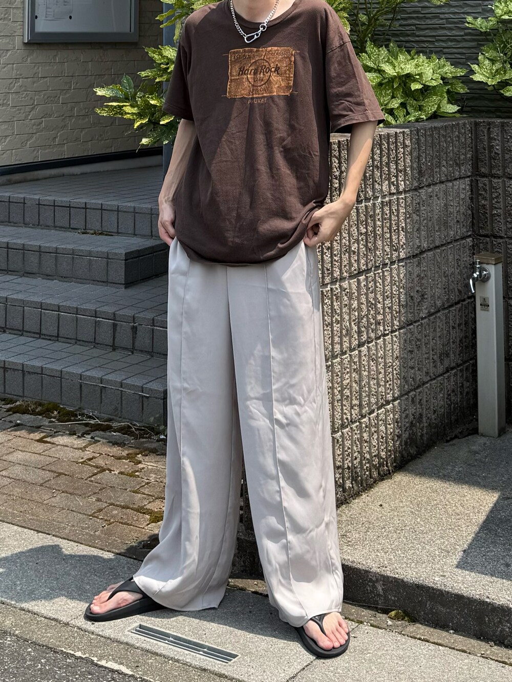 ブラウン系のTシャツ/カットソー、ホワイト系のスラックスを着用したメンズの夏コーディネートの3枚目の写真