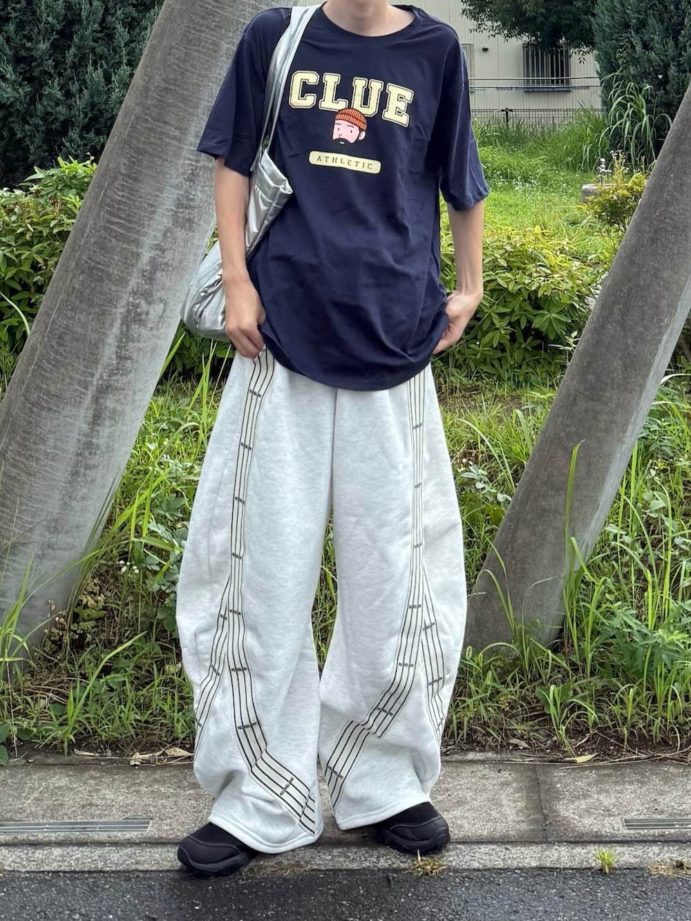 ブラック系のTシャツ/カットソー、グレー系のスウェットパンツを着用したメンズの夏コーディネートの3枚目の写真