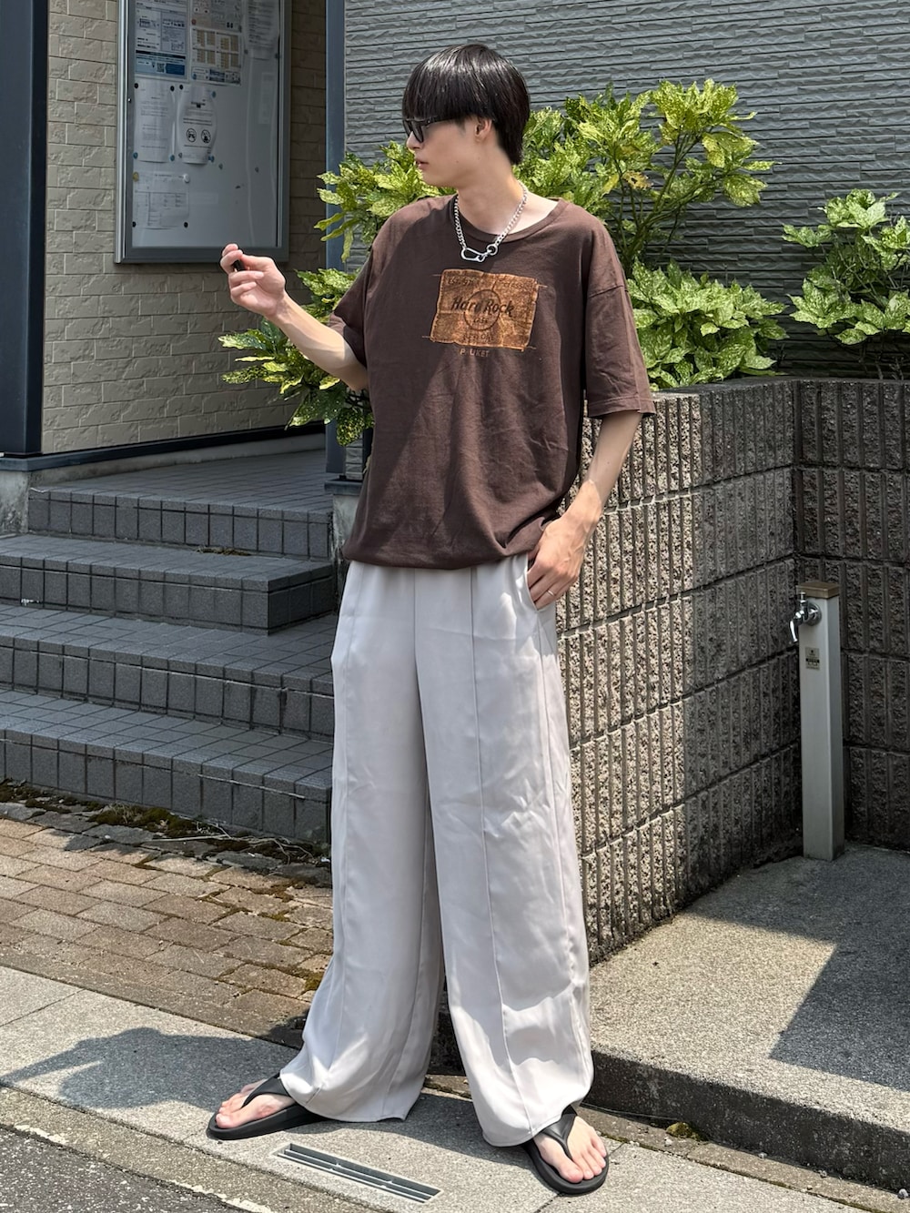 ブラウン系のTシャツ/カットソー、ホワイト系のスラックスを着用したメンズの夏コーディネートの2枚目の写真