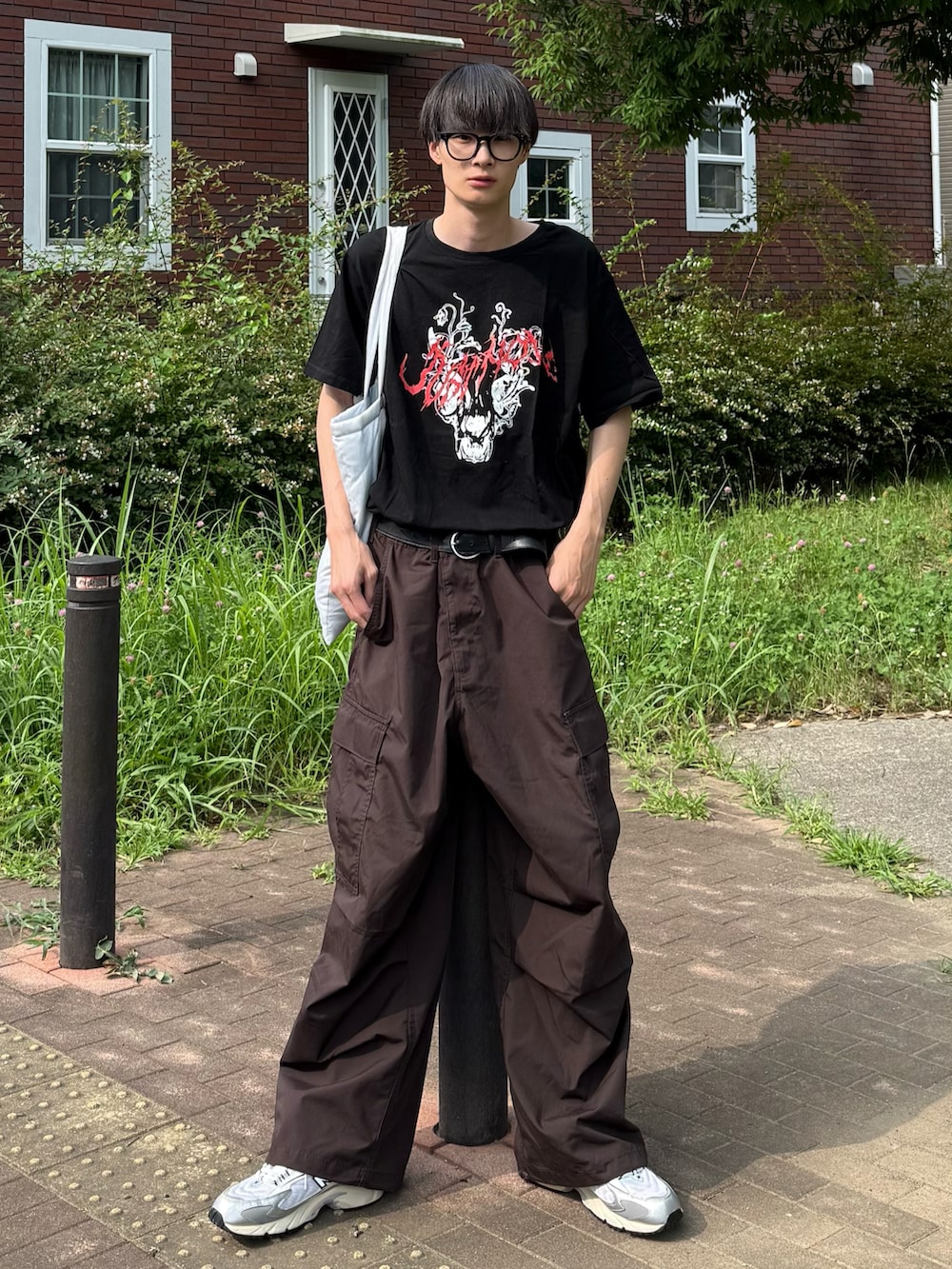 ブラック系のTシャツ/カットソー、ブラウン系のカーゴパンツを着用したメンズの夏コーディネートの2枚目の写真