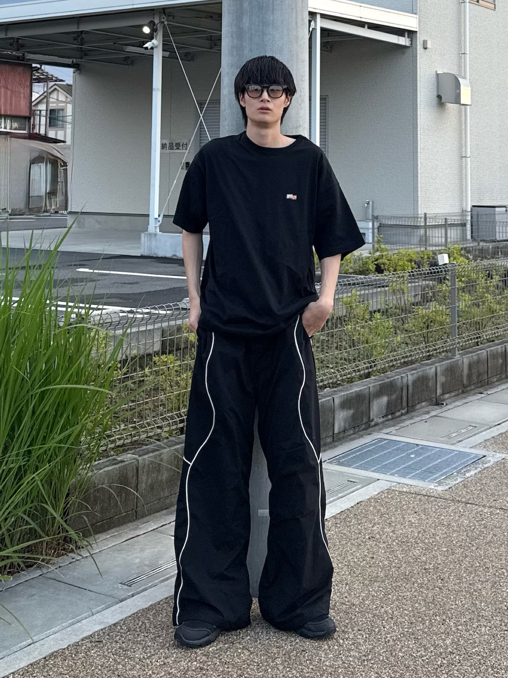 ブラック系のTシャツ/カットソーを着用したメンズの夏コーディネートの2枚目の写真