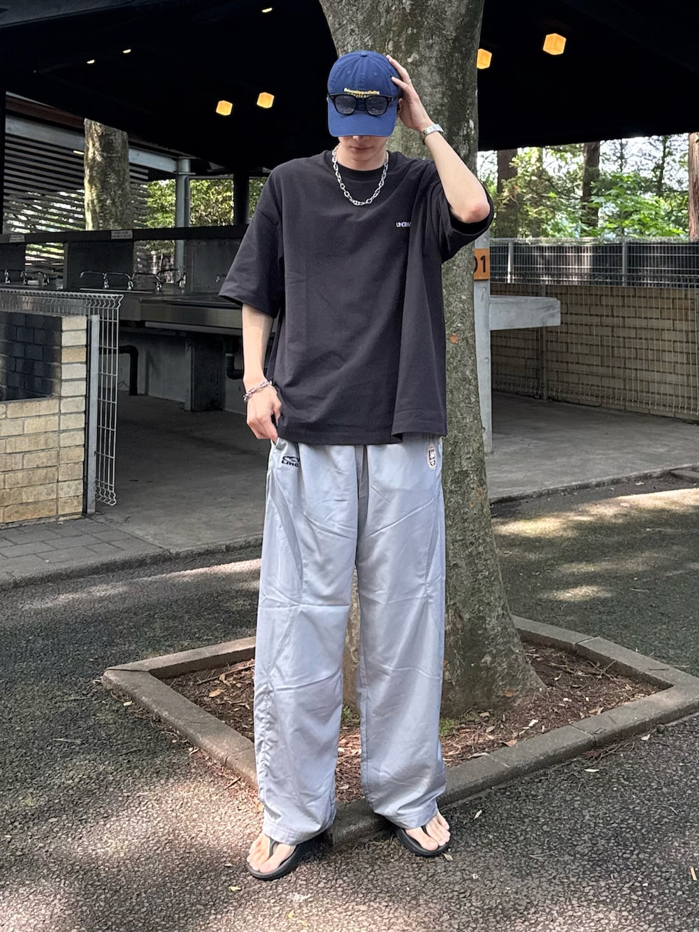 グレー系のカーゴパンツ、ブルー系のキャップを着用したメンズの夏コーディネートの2枚目の写真