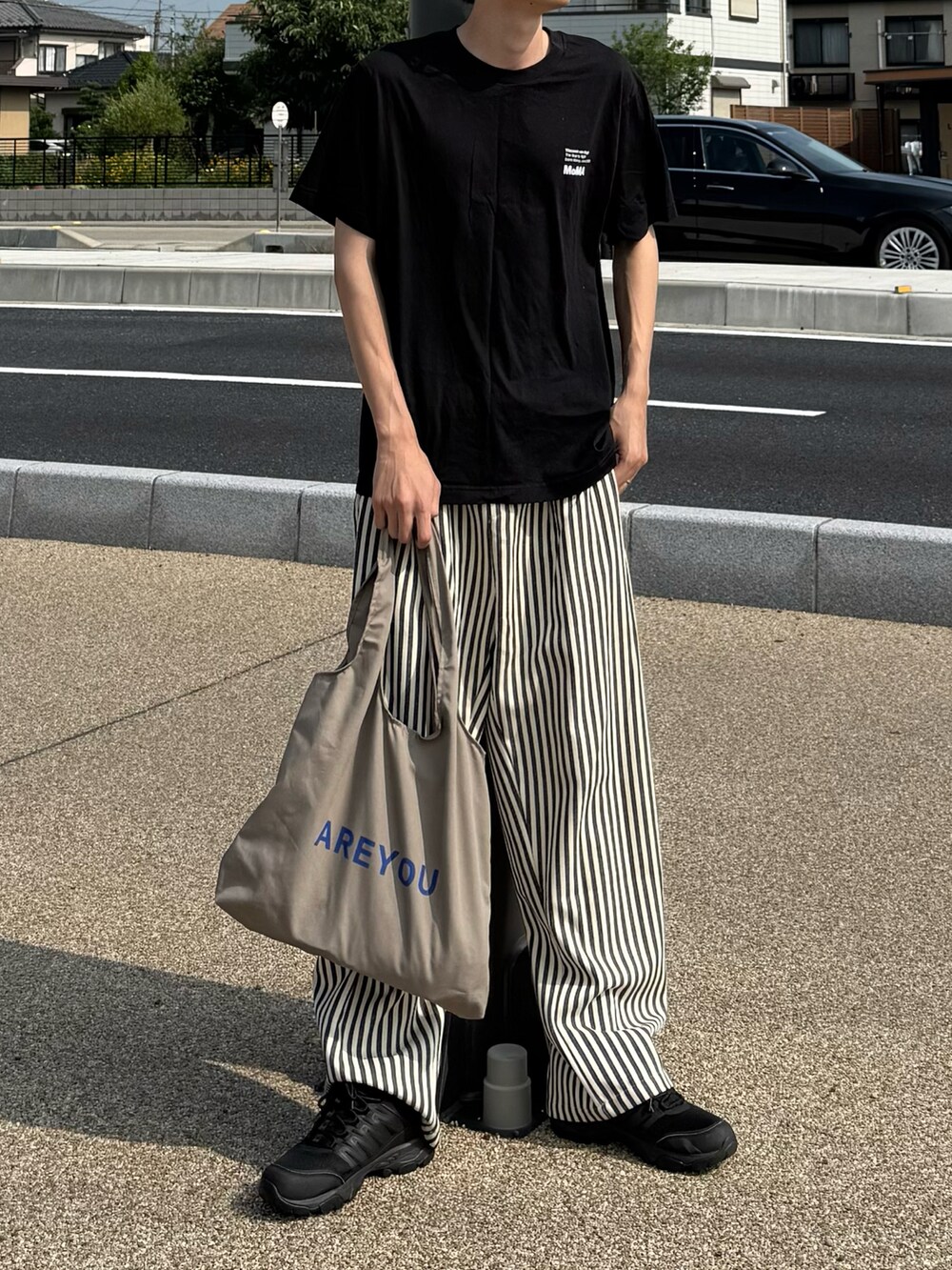 ブラック系のTシャツ/カットソーを着用したメンズの夏コーディネートの3枚目の写真