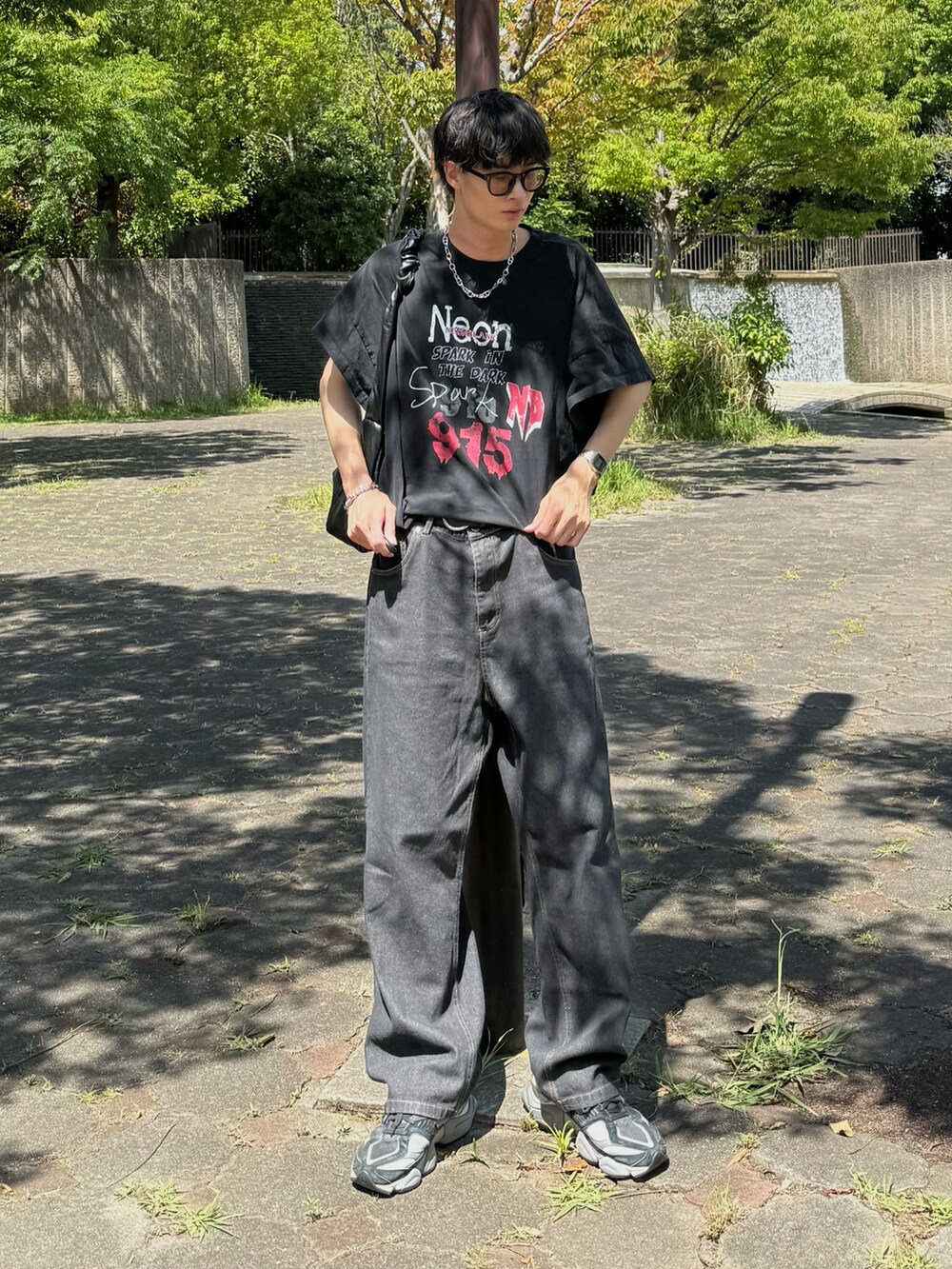 ブラック系のトップス、ブラック系のデニムパンツを着用したメンズの夏コーディネートの2枚目の写真