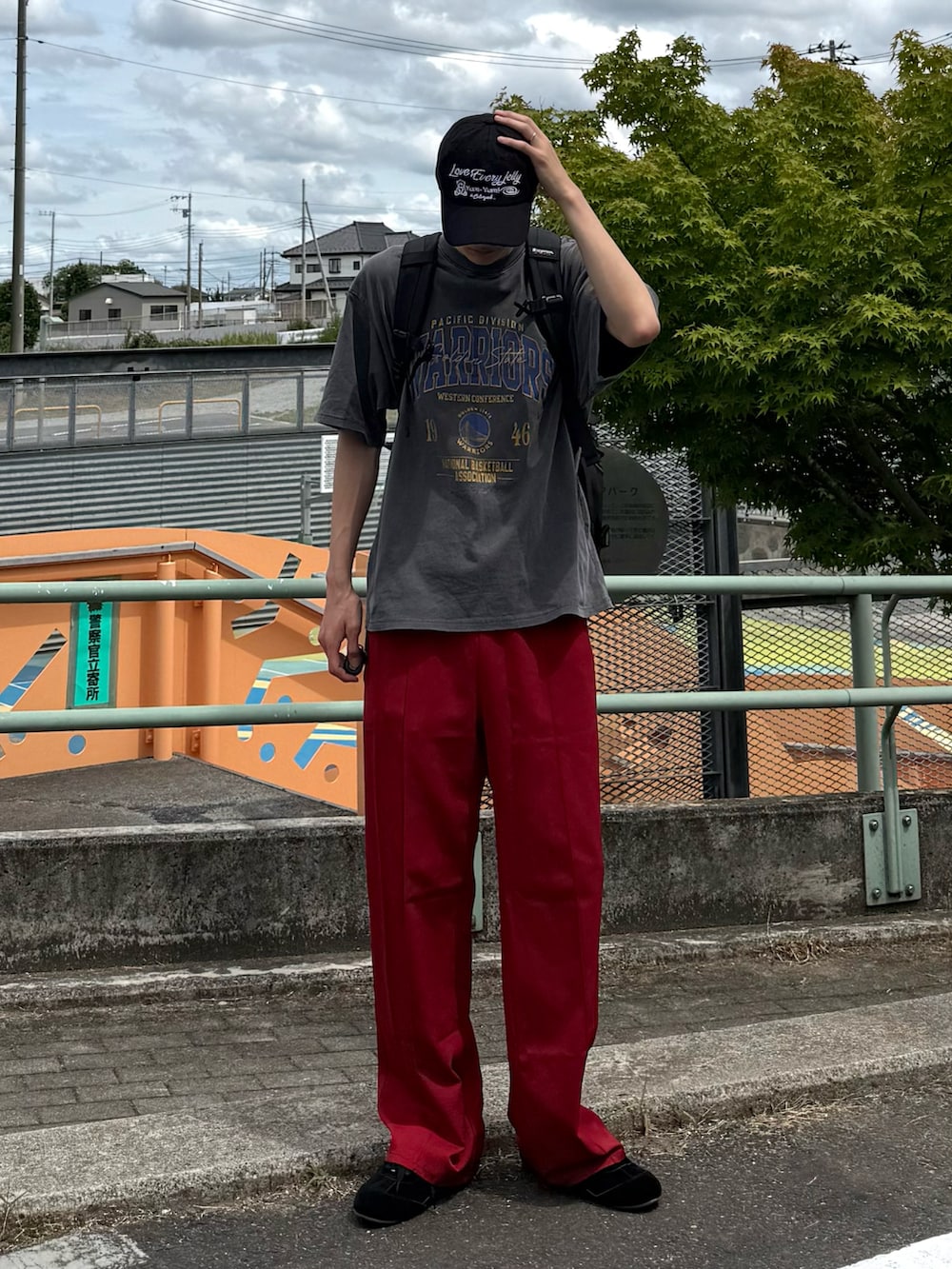 ブラック系のスニーカー、グレー系のTシャツ/カットソー、レッド系のスラックスを着用したメンズの夏コーディネートの2枚目の写真