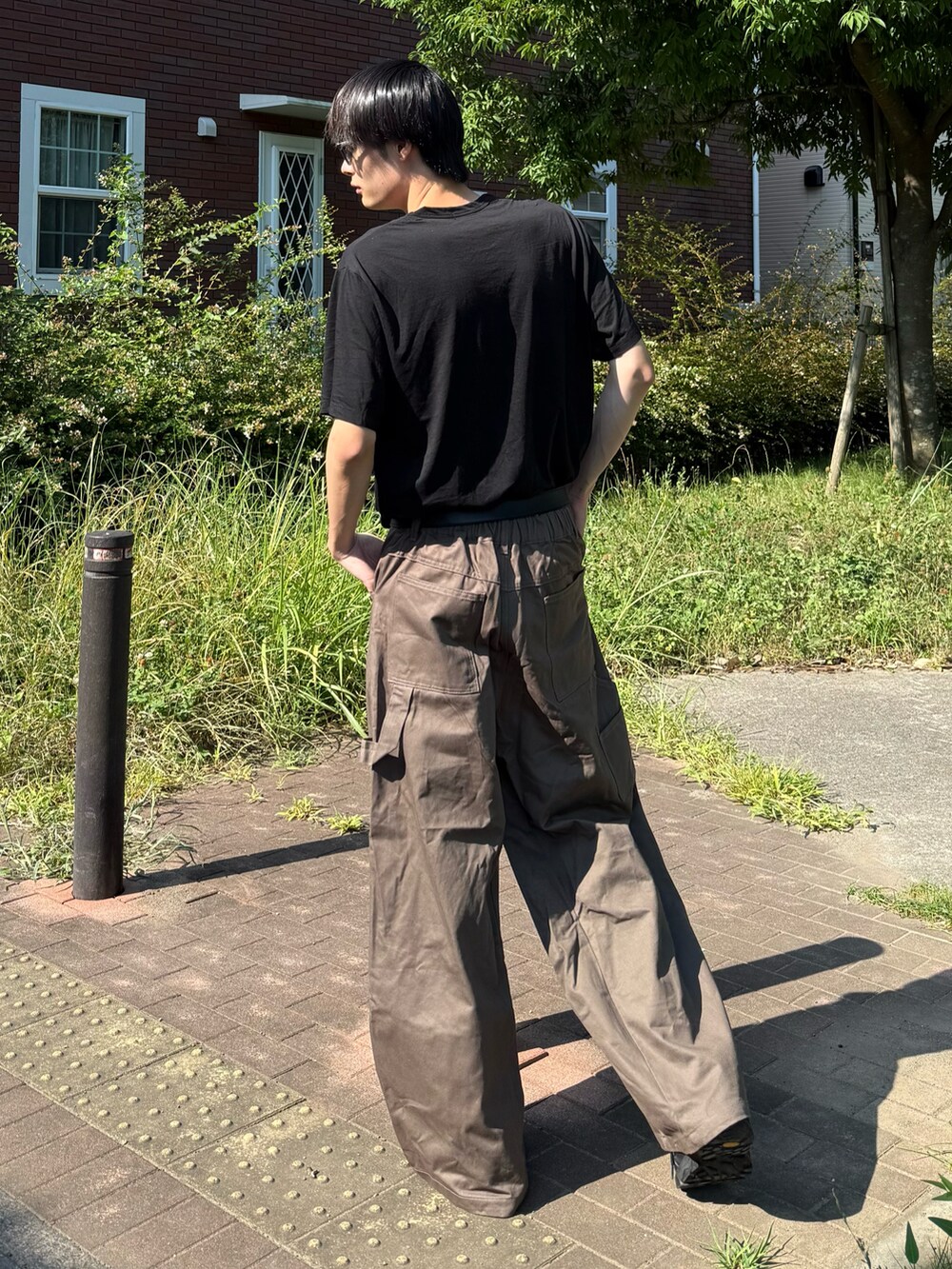 ブラック系のTシャツ/カットソーを着用したメンズの夏コーディネートの3枚目の写真
