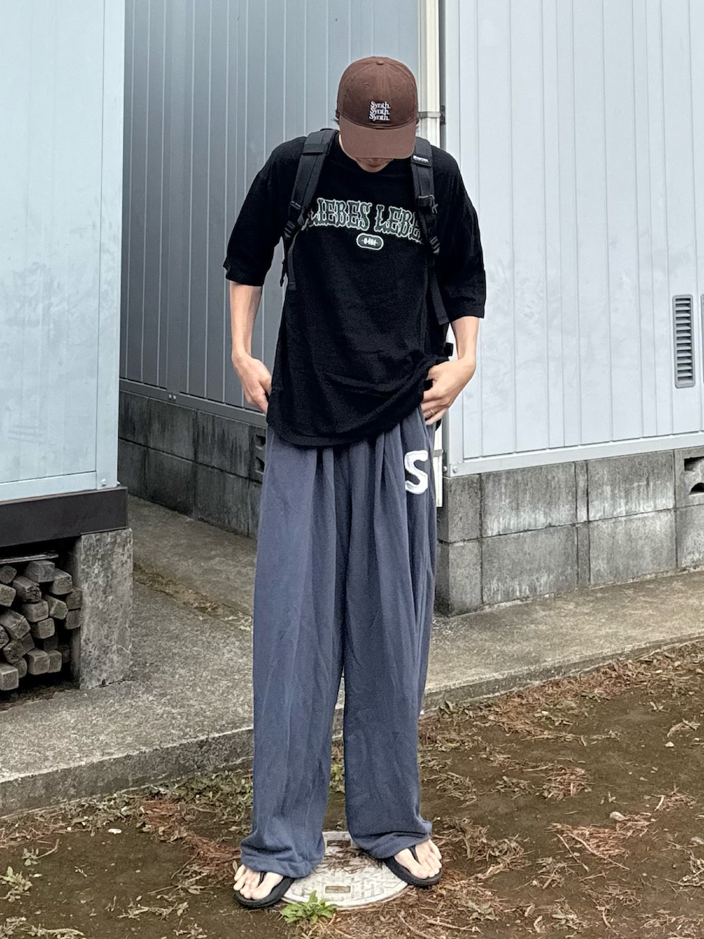 ブラック系のサンダル、ブラウン系のキャップを着用したメンズの夏コーディネートの2枚目の写真