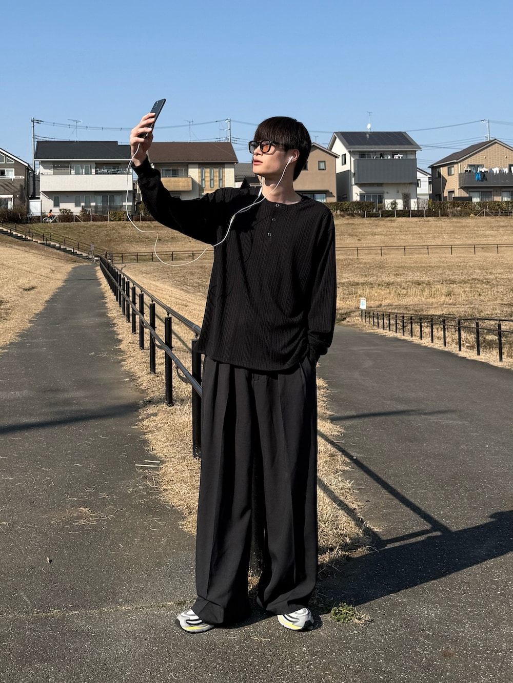 ブラック系のTシャツ/カットソーを着用したメンズの春コーディネートの2枚目の写真