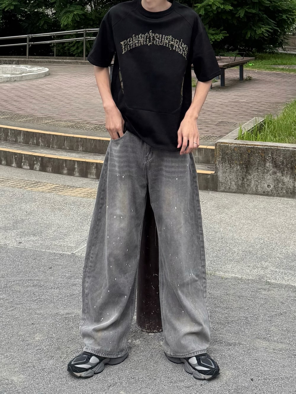 ブラック系のTシャツ/カットソー、グレー系のデニムパンツ、グレー系のシューズを着用したメンズの夏コーディネートの3枚目の写真