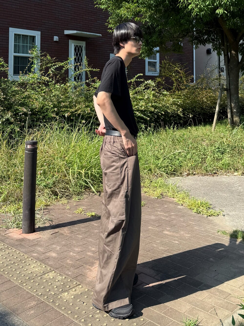 ブラック系のTシャツ/カットソーを着用したメンズの夏コーディネートの2枚目の写真