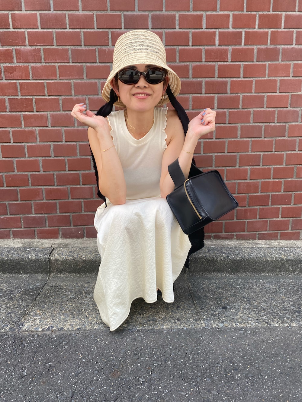 ホワイト系のスカート、ホワイト系のTシャツ/カットソー、ホワイト系のハットを着用したレディースの夏コーディネートの2枚目の写真