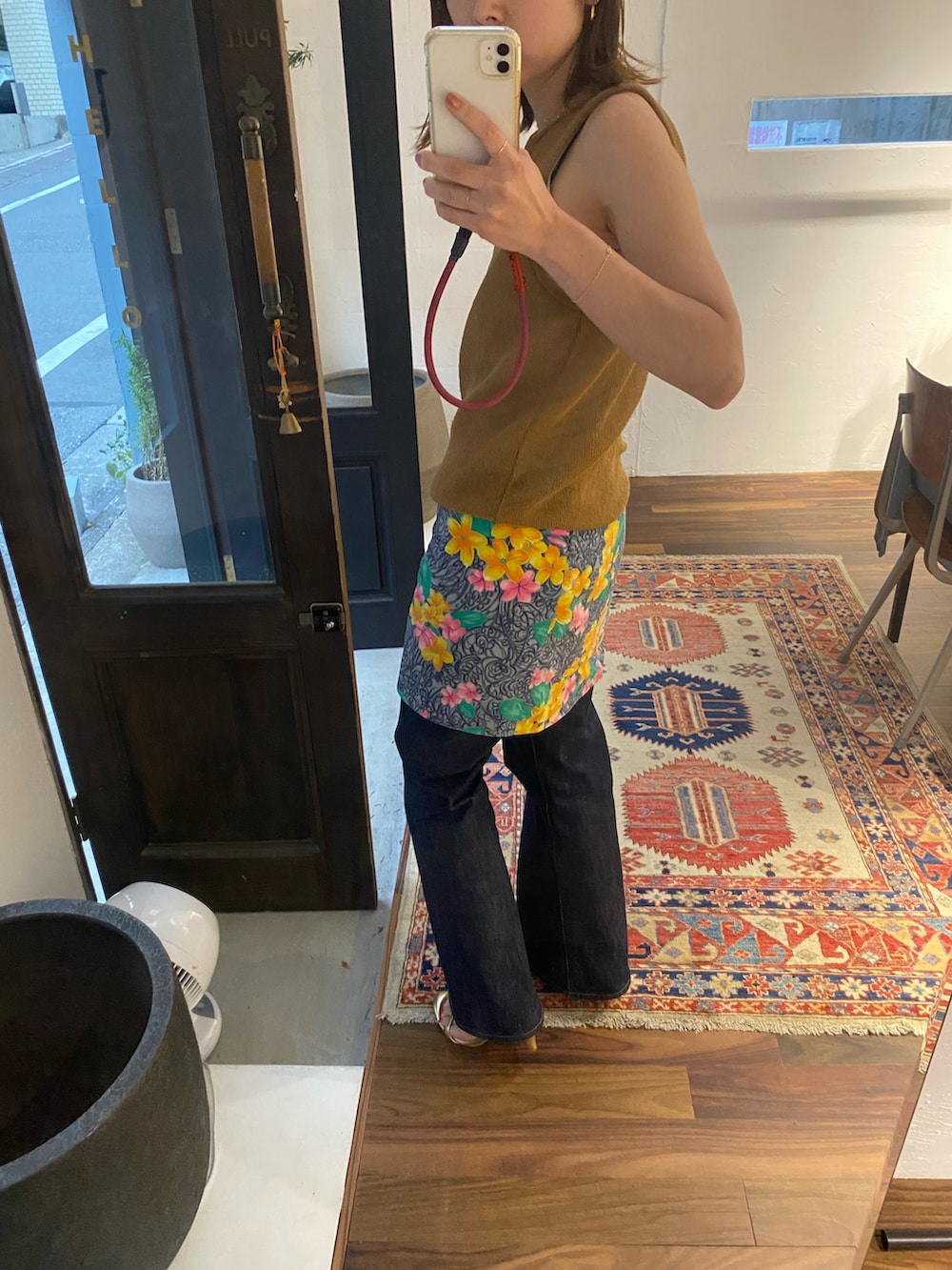 ベージュ系のベスト、ブルー系のデニムパンツ、グレー系のキャミソールを着用したレディースの夏コーディネートの2枚目の写真
