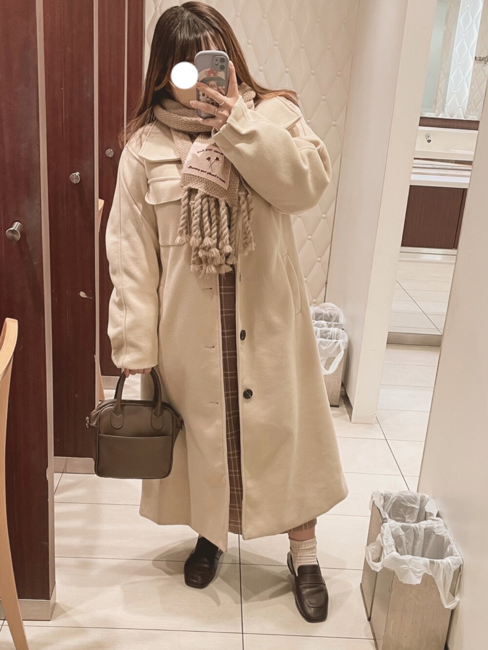 ブラウン系のショルダーバッグ、ブラウン系のローファー、ブラウン系のニット/セーターを着用したレディースの冬コーディネートの2枚目の写真