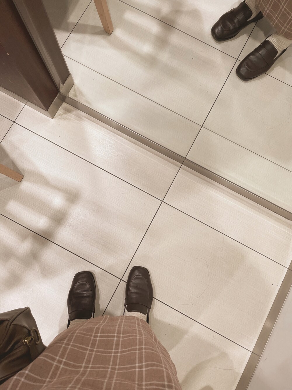 ブラウン系のショルダーバッグ、ブラウン系のローファー、ブラウン系のニット/セーターを着用したレディースの冬コーディネートの3枚目の写真