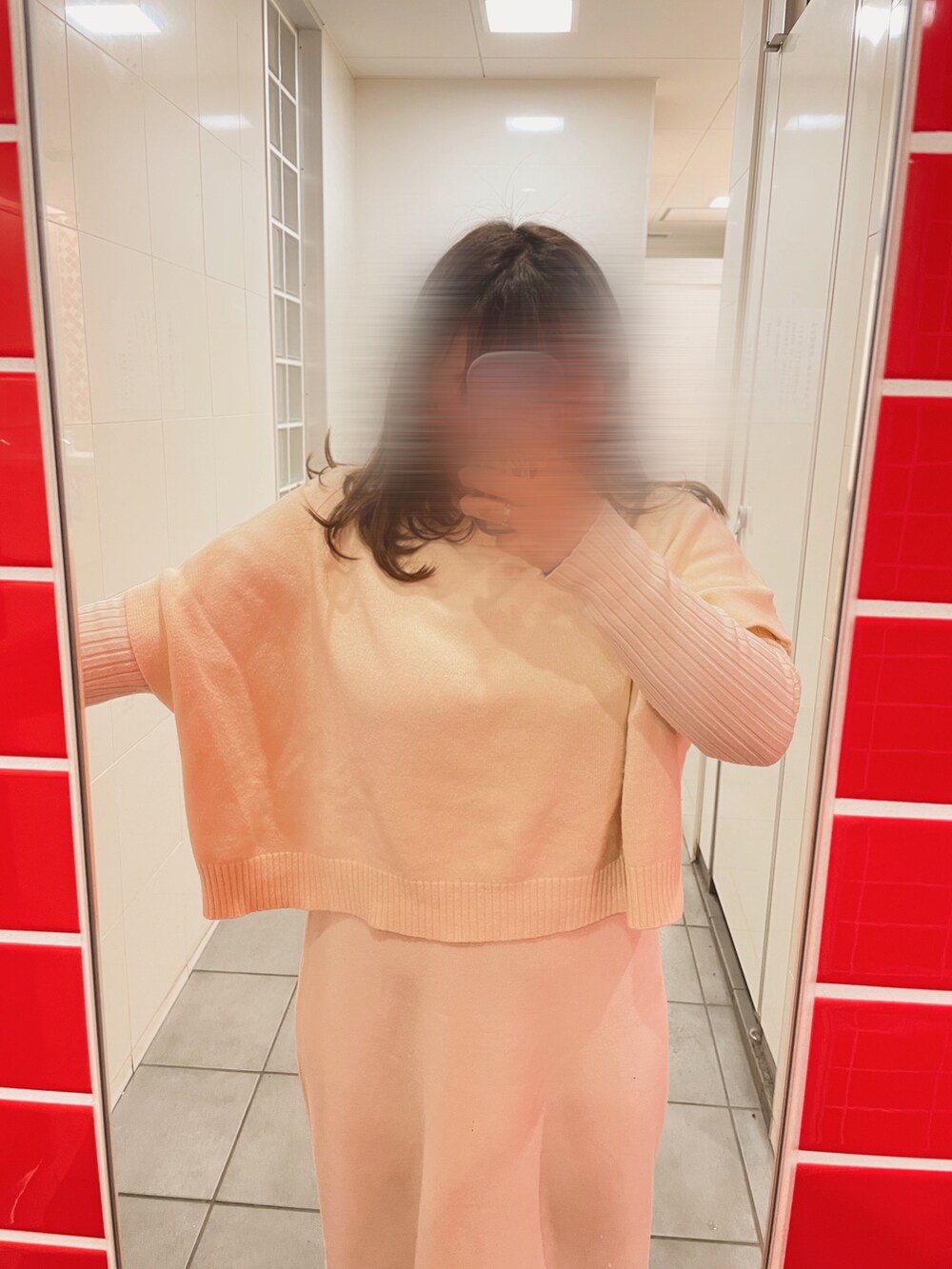 ブラック系のボストンバッグ、ホワイト系のワンピース、ブラック系のブーツを着用したレディースの冬コーディネートの3枚目の写真