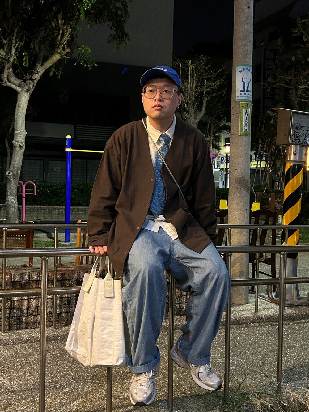 ブラウン系のノーカラージャケット、ブルー系のデニムパンツ、シルバー系のスニーカーを着用したメンズの冬コーディネートの2枚目の写真