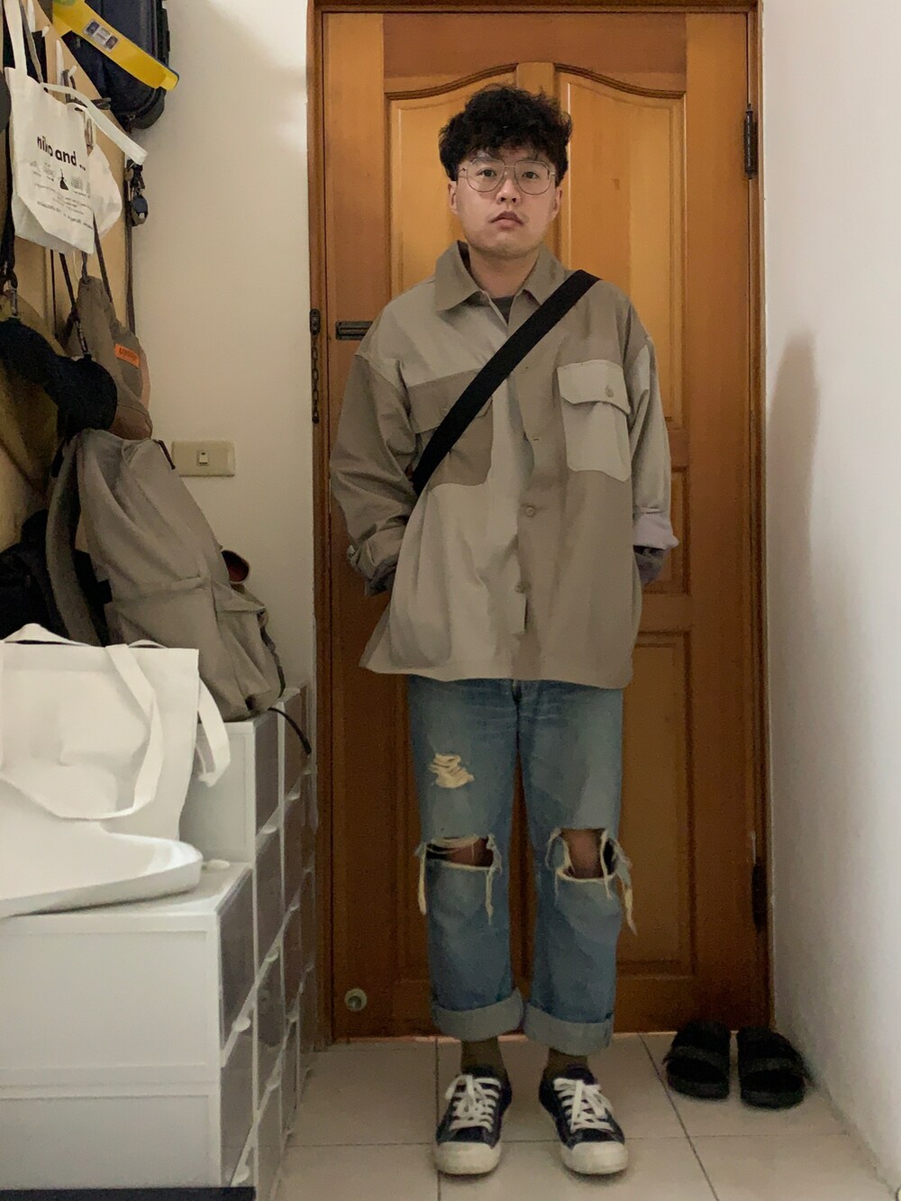 ベージュ系のジャケット/アウター、イエロー系のメッセンジャーバッグ、ブルー系のデニムパンツを着用したメンズの春コーディネートの2枚目の写真