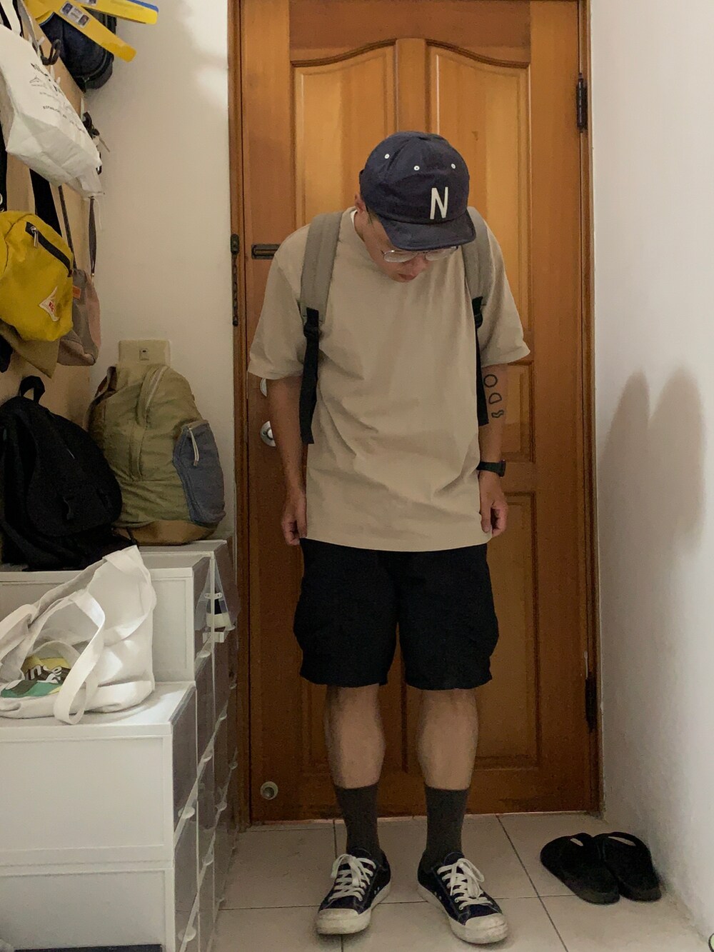 ベージュ系のTシャツ/カットソー、ブラック系のカーゴパンツを着用したメンズの夏コーディネートの2枚目の写真