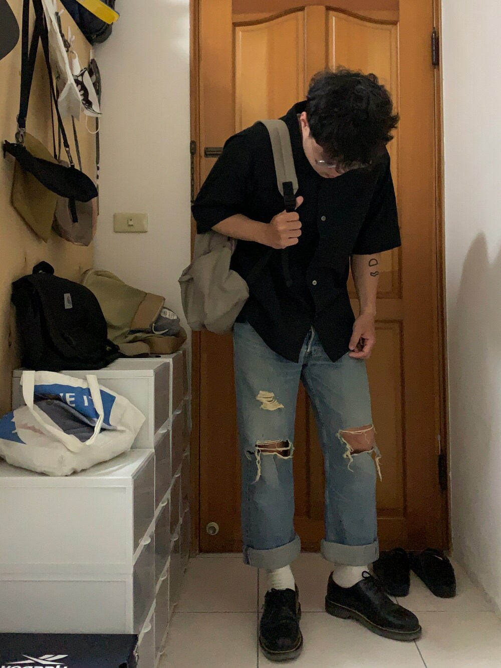 ブラック系のシャツ/ブラウス、ブルー系のデニムパンツ、ブラック系のシューズを着用したメンズの春コーディネートの2枚目の写真