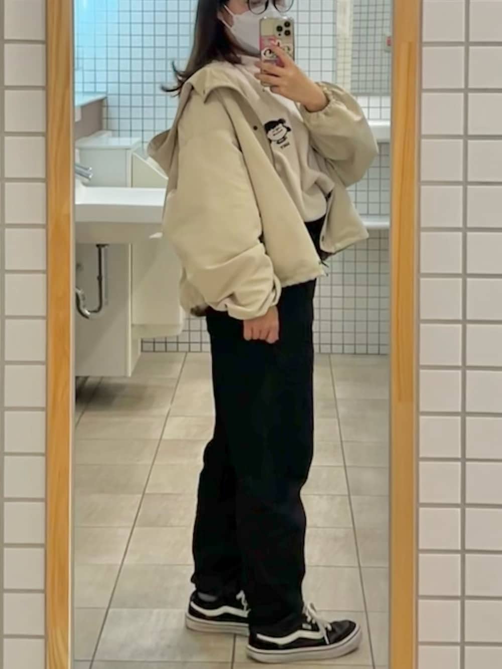 ブラック系のデニムパンツ、ブラック系のスニーカー、ホワイト系のスウェットを着用したレディースの春コーディネートの2枚目の写真