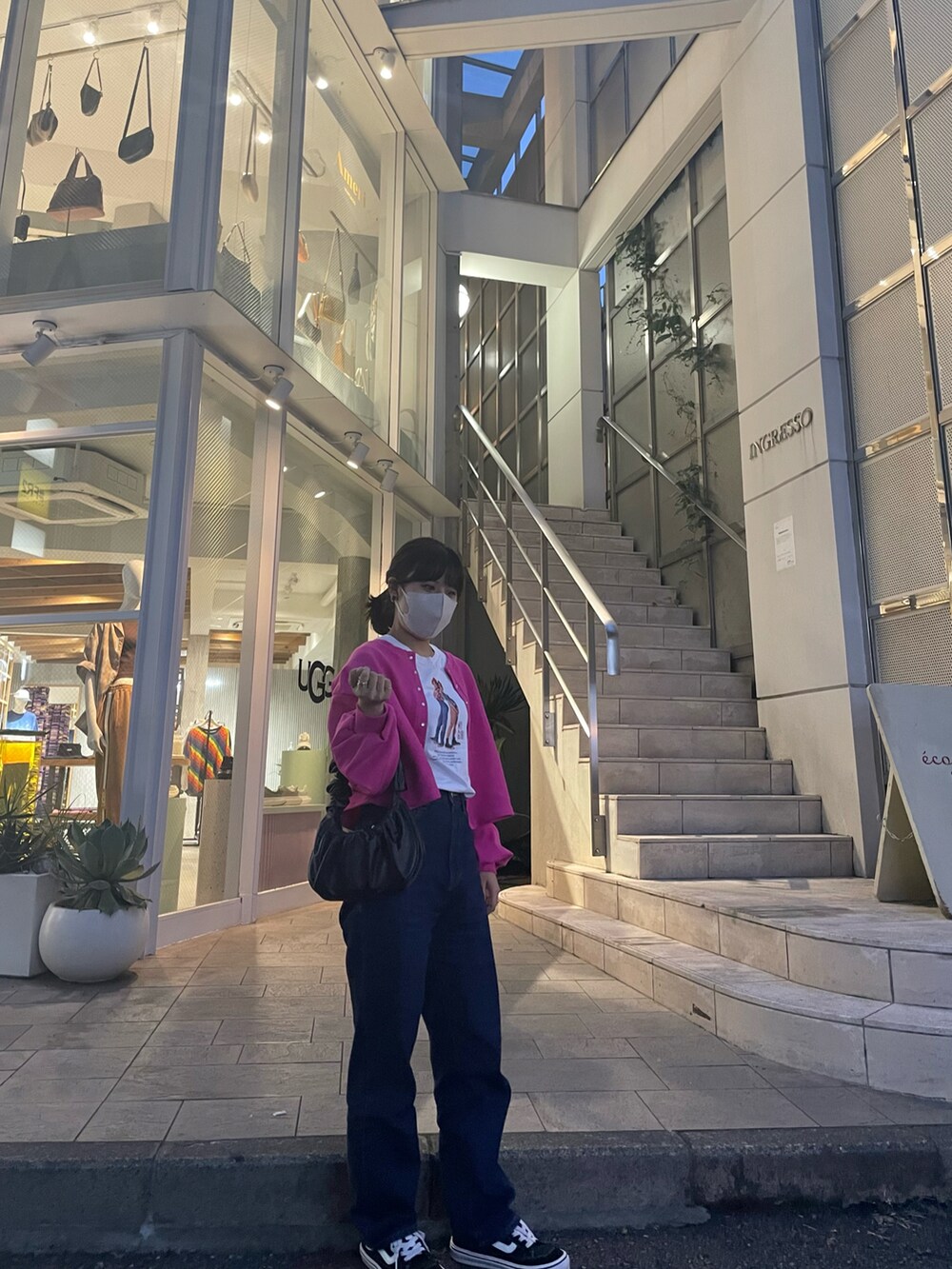 ピンク系のカーディガン/ボレロ、ホワイト系のTシャツ/カットソー、ブラック系のハンドバッグを着用したレディースの夏コーディネートの2枚目の写真