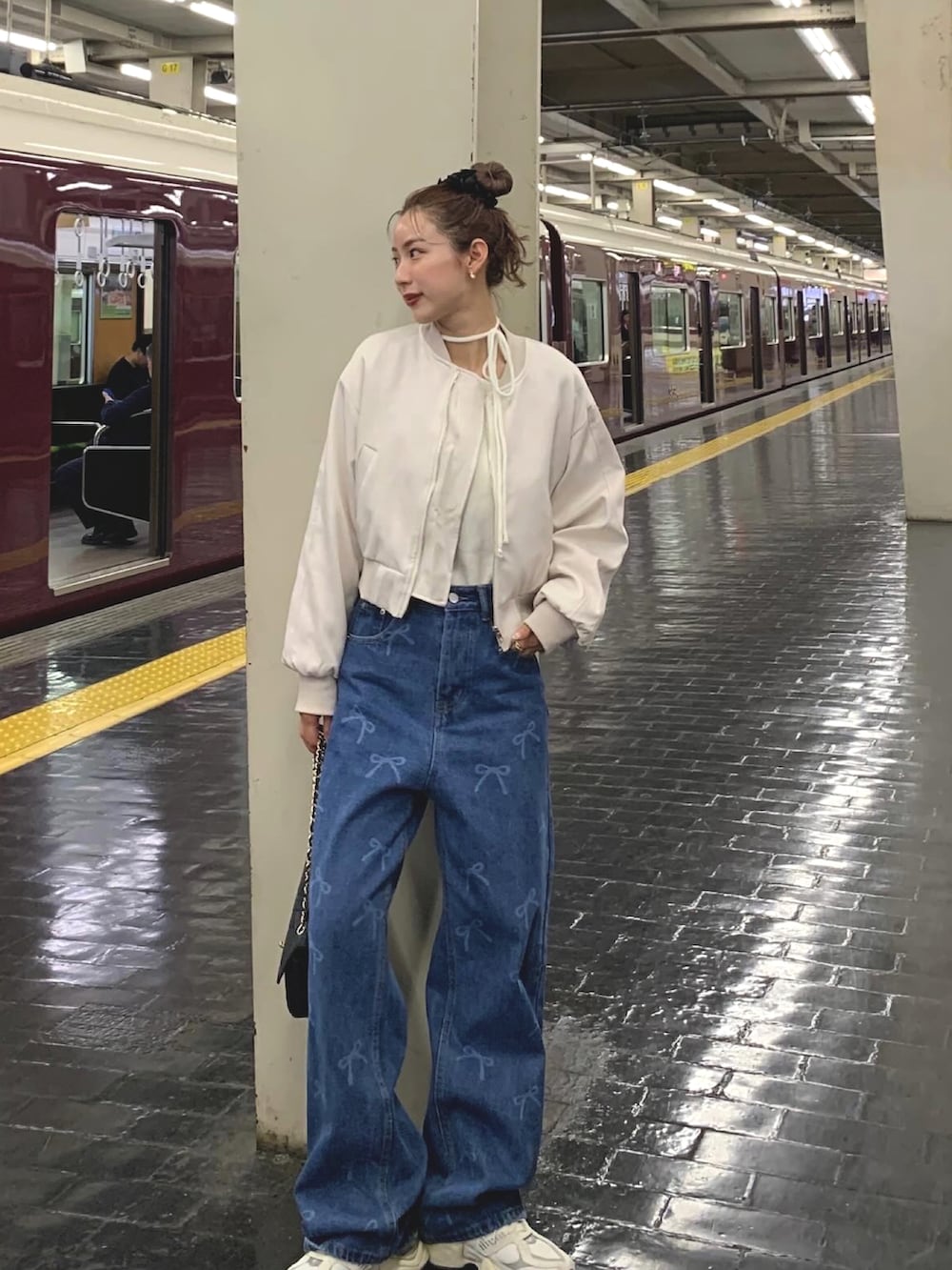 ホワイト系のスニーカー、ブルー系のデニムパンツ、ベージュ系のMA-1を着用したレディースの春コーディネートの2枚目の写真