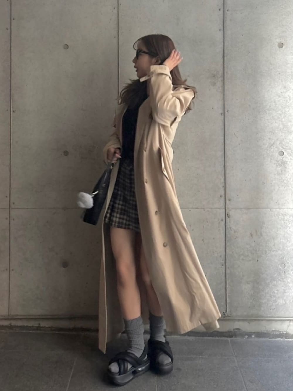 ブラウン系のスカート、ブラック系のカーディガン/ボレロ、ブラック系のサンダルを着用したレディースの春コーディネートの2枚目の写真