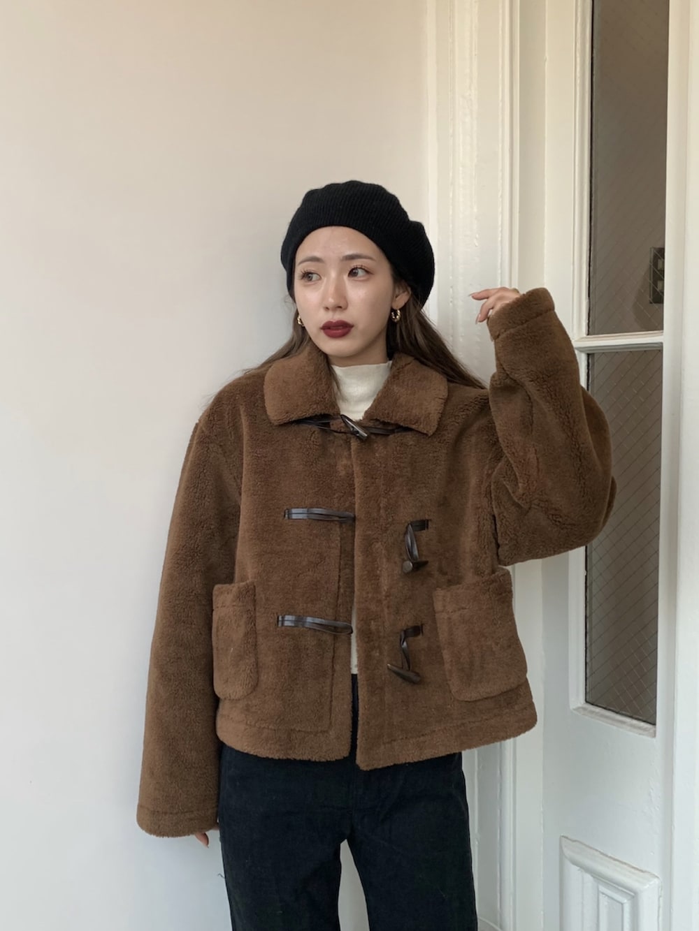 ブラック系のパンツ、ブラック系のサンダル、ブラウン系のダッフルコートを着用したレディースの秋コーディネートの2枚目の写真