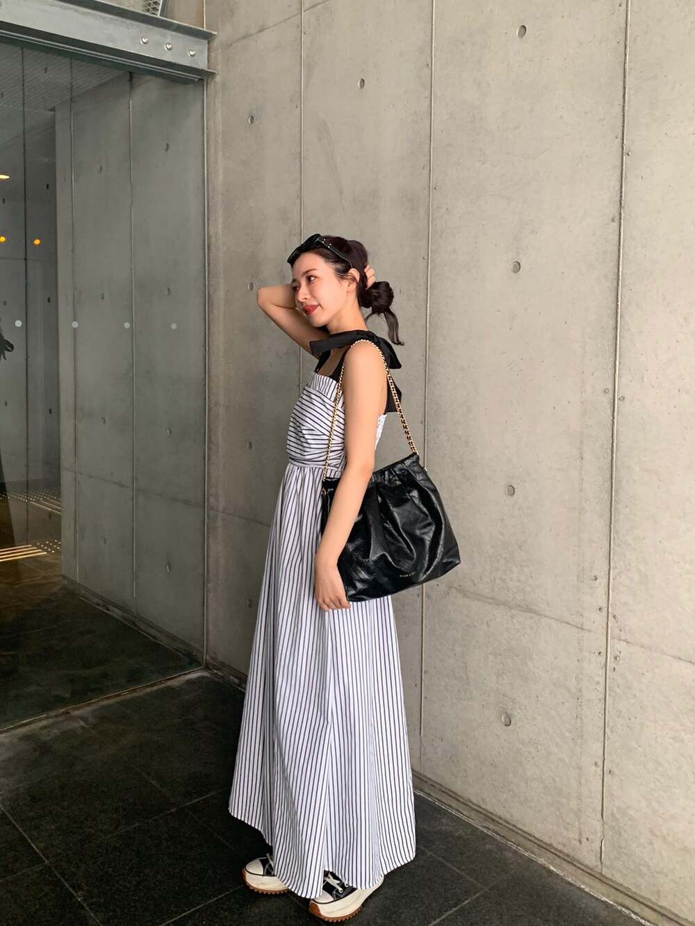 ブラック系のショルダーバッグ、ホワイト系のワンピース/ドレス、ブラック系のシューズを着用したレディースの春コーディネートの3枚目の写真