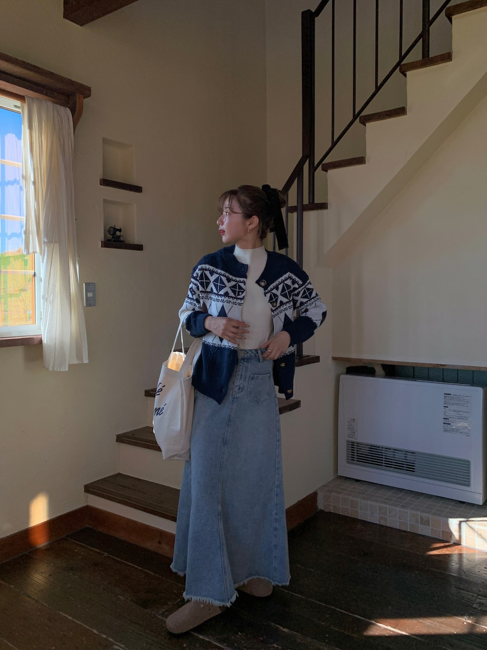 ホワイト系のトートバッグ、ブルー系のデニムスカート、ベージュ系のスリッポンを着用したレディースの秋コーディネートの2枚目の写真
