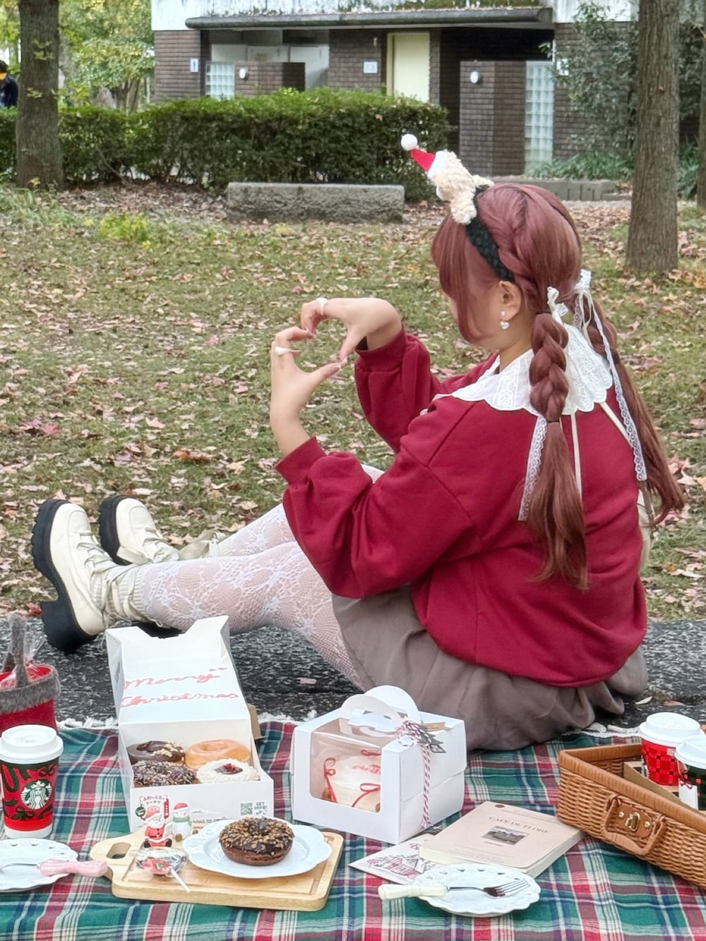 レッド系のスウェット、ブラウン系のスカート、ホワイト系のブーツを着用したレディースの冬コーディネートの2枚目の写真