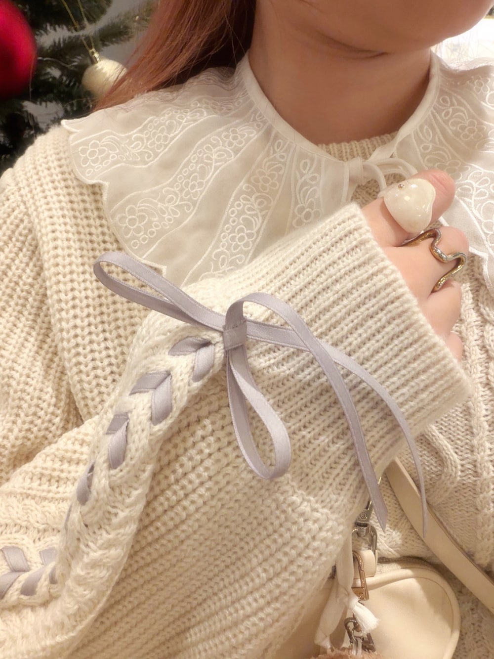 ホワイト系のニット/セーター、ホワイト系のスカート、ホワイト系のショルダーバッグを着用したレディースの冬コーディネートの4枚目の写真