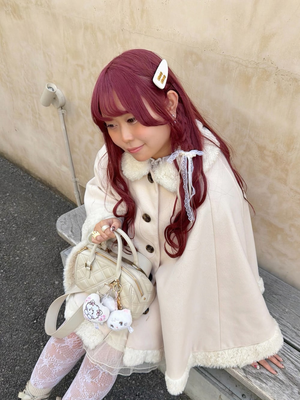ホワイト系のニット/セーター、ホワイト系のブーツ、ホワイト系のポンチョを着用したレディースの春コーディネートの5枚目の写真