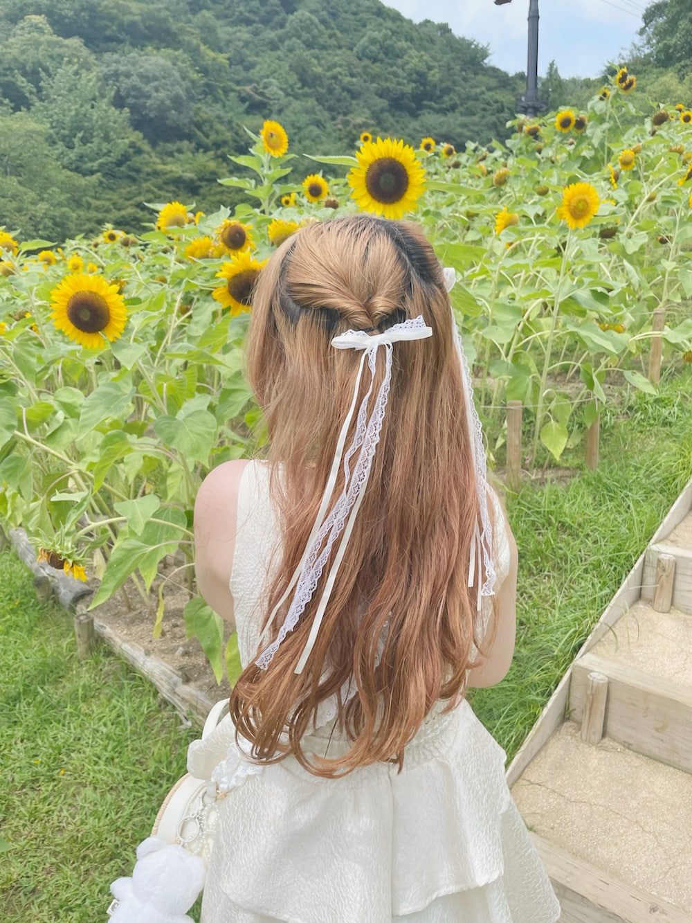 ホワイト系のサンダル、ホワイト系のワンピース、ベージュ系のショルダーバッグを着用したレディースの秋コーディネートの2枚目の写真